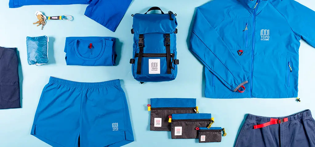 Selection of Blue Topo Designs Products Including Shirt, Shorts and Bags