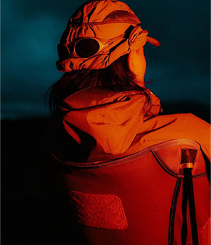 Person sitting on a Helinox chair at dusk, showcasing lightweight, durable outdoor gear perfect for adventures and camping.