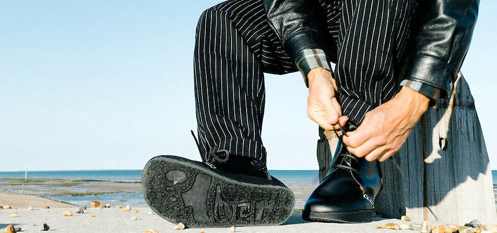 Man Sitting on a Beach Tying Yogi x YMC Boot Laces
