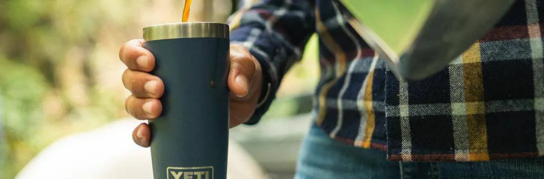 Man Wearing a Checked Shirt Holding a Yeti Drinks Tumbler